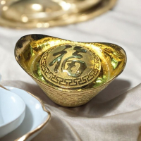 金元寶擺件：傳統財富象徵，增添家居風水與幸福氣息探索這款金元寶擺件，將中國傳統財富象徵融入您的生活！以經典元寶造型設計，表面閃耀金光，傳遞吉祥氛圍。中央精雕「福」字，寓意招福納財，適合擺放於家中或辦公室，助您提升風水運勢與財運。無論是為居家裝飾、風水擺設，或是作為送禮佳品，這款小巧精緻的擺件都能為空間增添富貴氣息，讓您在追求財運和幸福的旅程中，感受到滿滿的祝福與心意。